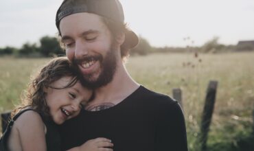 Man and daughter hugging in field